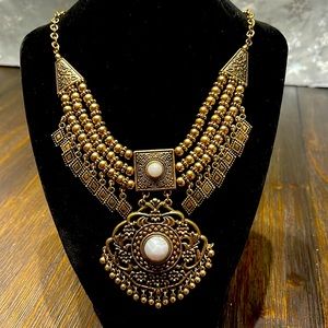 Bohemian styled gold color necklace with two white marble like accents